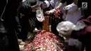 Keluarga dan kerabat menaburkan bunga di makam almarhum istri kedua Opick, Wulan Mayasari di TPU Semper, Jakarta, Senin (19/3). Wulan Mayasari dan bayi yang dikandungnya meninggal dunia. (Liputan6.com/Faizal Fanani)