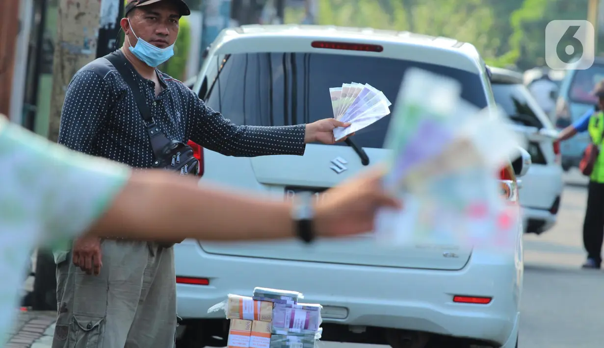 Penjual jasa penukaran uang pecahan menunggu konsumen di Jalan Otista Raya di Karawaci, Kota Tangerang, Senin (10/5/2021). Penjual jasa penukaran uang baru musiman tersebut mulai bermunculan menjelang lebaran yang dikenakan tarif jasa sebesar 10 persen. (Liputan6.com/Angga Yuniar)