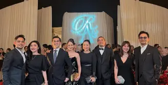 Aaliyah tampil anggun dalam strapless black gown beraksen detail berkilau yang memberi sentuhan glam tanpa berlebihan. Thariq memilih setelan jas hitam klasik dengan boutonniere putih, terlihat kontras sekaligus rapi. Kehadiran sang buah hati yang juga mengenakan busana hitam membuat tampilan keluarga kecil ini terlihat sangat kompak dan manis. [@aaliyah.massaid].