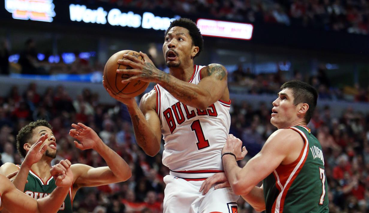 Derrick Rose melakukan jump shot diantara pengawalan ketat pemain Bucks (Jerry Lai-USA TODAY Sports)