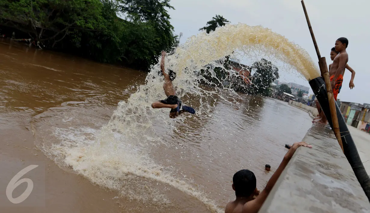 Anak - anak berlompat di kali Ciliwung, Kampung Pulo, Jakarta Timur, Sabtu (12/3). Kurangnya lahan bermain membuat mereka terpaksa bermain di bantaran kali Ciliwung. (Liputan6.com/Gempur M Surya)