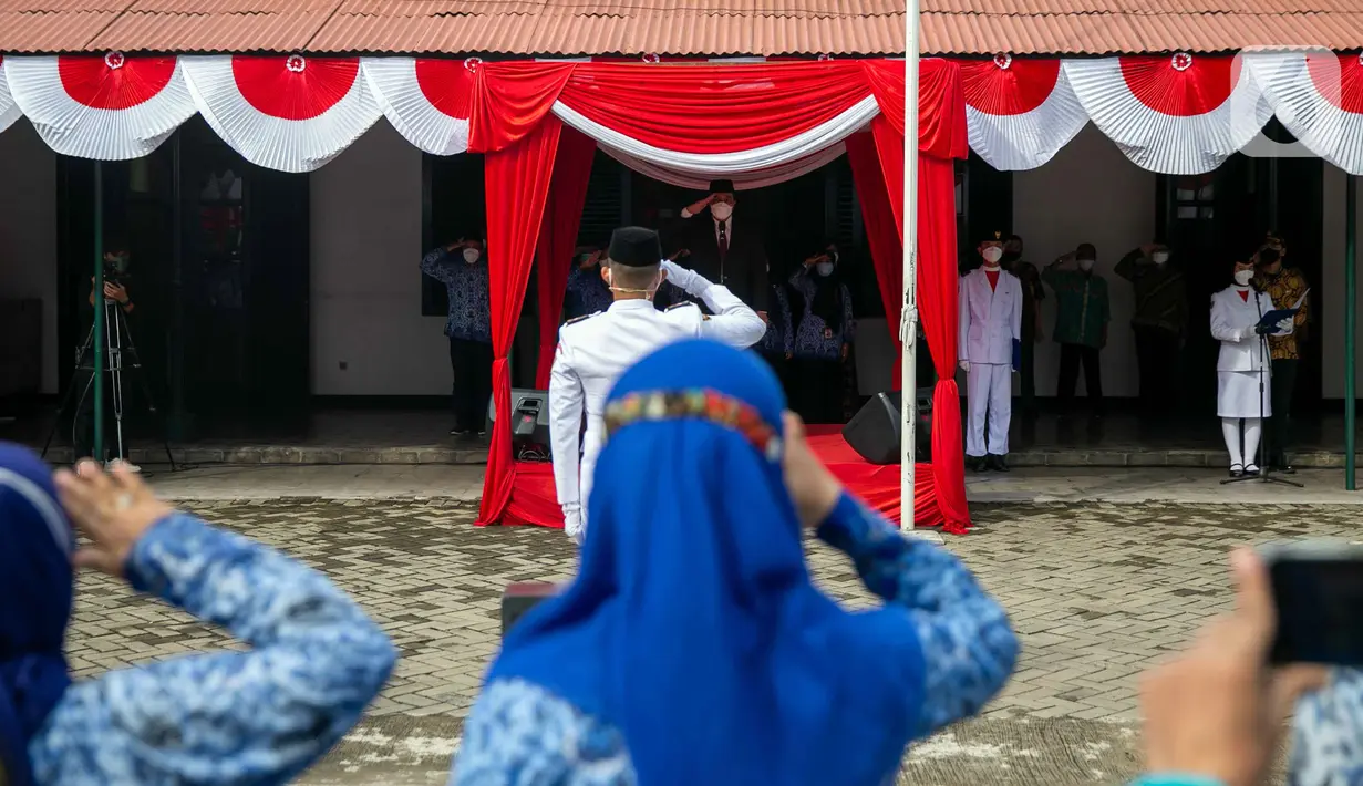 Anggota paskibra dan peserta melakukan hormat saat pengibaran bendera Merah Putih di depan Museum Sumpah Pemuda, Jakarta, Kamis (28/10/2021). Upacara tersebut dilaksanakan untuk memperingati Hari Sumpah Pemuda ke-93. (Liputan6.com/Faizal Fanani)