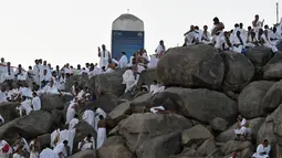 Jemaah haji mengunjungi bukit Jabal Rahmah di Padang Arafah, sebelah tenggara kota suci Makkah, Arab Saudi, Sabtu (10/8/2019). Menjelang Wukuf Arafah, Jabal Rahma yang terletak di Padang Arafah banyak dikunjungi peziarah haji. (FETHI BELAID / AFP)