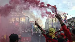 Sejumlah buruh menyalakan bom asap saat menutup aksi Hari Buruh Internasional di Jalan Medan Merdeka Barat, Jakarta, Rabu (5/1/2019). Buruh dari berbagai organisasi merayakan Hari Buruh Internasional di Kawasan Silang Barat Daya Monas. (Liputan6.com/Helmi Fithriansyah)