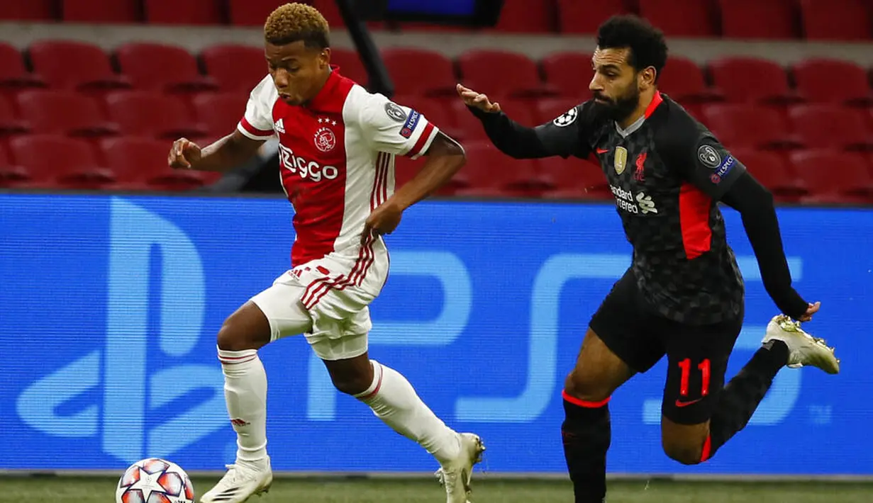 Penyerang Liverpool, Mohamed Salah, mengejar pemain Ajax Amsterdam, David Neres, pada laga Liga Champions di Stadion Johan Cruyff, Kamis (22/10/2020). Liverpool menang dengan skor 1-0. (AP/Peter Dejong)