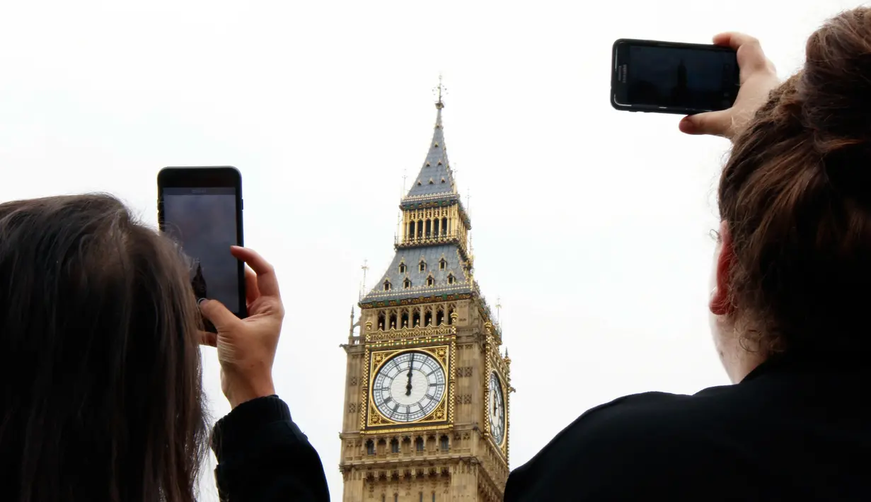 Pengunjung menggunakan ponsel merekam dentang Big Ben untuk terakhir kalinya di Elizabeth Tower, London, Senin (21/8). Menara jam itu berhenti berdentang hingga empat tahun mendatang guna renovasi besar-besaran di Gedung Parlemen (AP Photo/Frank Augstein)