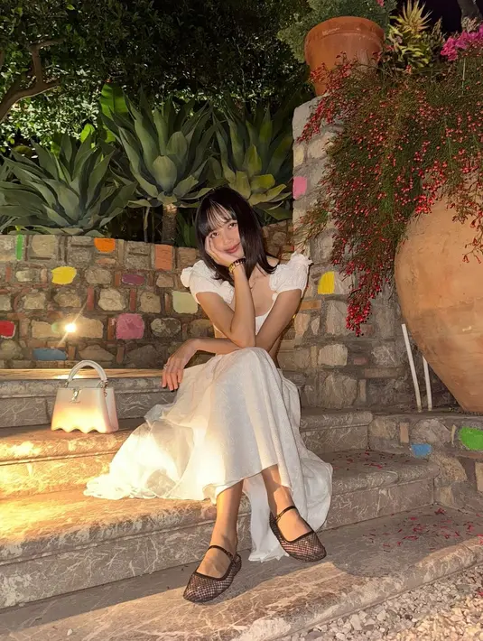 Di beberapa potret terbarunya, Lisa memperlihatkan body goalsnya; perutnya yang tipis dengan setelan cropped top dan rok panjang yang sama-sama berwarna putih. [Foto: Instagram/lalalalisa_m]