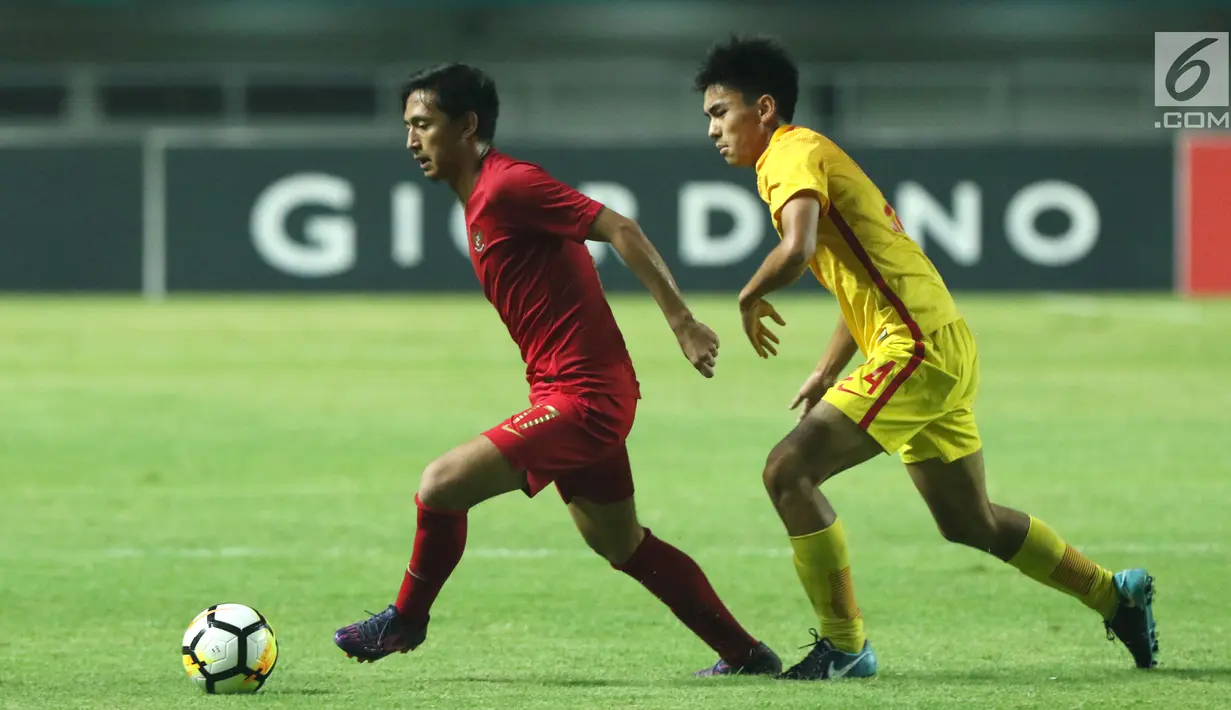 Pemain depan Timnas Indonesia U-19. Hanis Saghara Putra (kiri) mencoba melewati pemain China U-19, Ao Chen pada PSSI 88th U-19 International Tournament di Stadion Pakansari, Selasa (25/9). Indonesia kalah 0-3. (Liputan6.com/Helmi Fithriansyah)