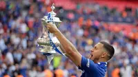 Gelandang Chelsea, Eden Hazard mengangkat trofi Piala FA usai pertandingan melawan Manchester United pada babak final Piala FA di stadion Wembley di London (19/5). Chelsea mengalahkan MU 1-0. (AP Photo / Tim Ireland)