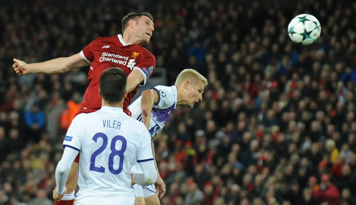 Pemain Liverpool, James Milner berebut bola dengan pemain Maribor, Martin Milec pada laga lanjutan Grup E Liga Champions di Anfield, Kamis (2/11). Liverpool membuka lebar jalannya menuju babak 16 besar usai menang  3-0 atas Maribor. (AP/Rui Vieira)