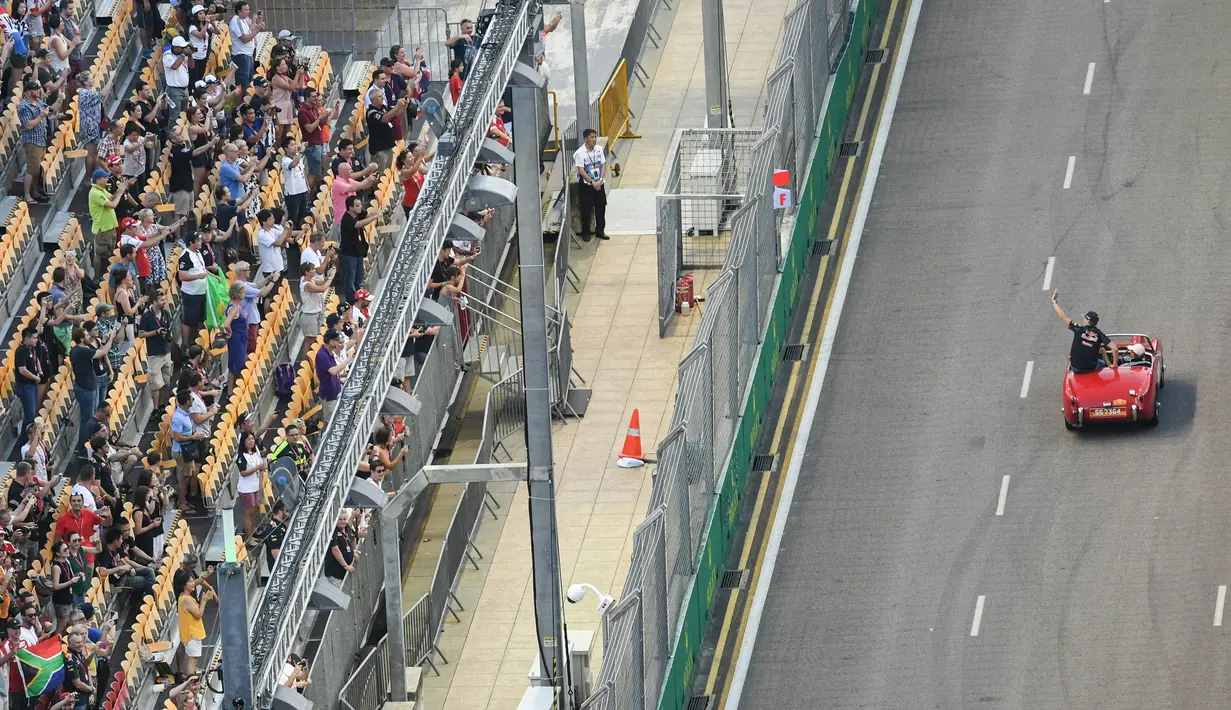 Pembalap Formula 1 Red Bull asal Belanda, Max Verstappen menyapa pengemar saat berada di mobil Mercedes-Benz klasik saat mengikuti parade jelang Grand Prix Formula 1 Malaysia di Sirkuit Internasional Sepang, Malaysia, (2/10). (AFP PHOTO/Danial Hakim)