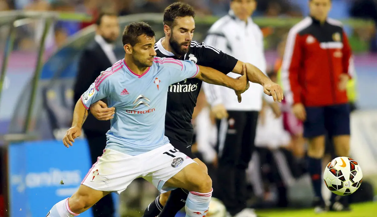 Bek Celta Vigo, Jonny Castro (kiri) berebut bola dengan bek Real Madrid Daniel Carvajal pada laga Liga Spanyol di Stadion Balaidos , Spanyol, Senin (27/4/2015). Real Madrid menang 4-2 atas Celta Vigo. (REUTERS/Miguel Vidal)