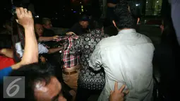 Massa pendukung Bupati Empat Lawang, Sumatera Selatan Budi Antoni Aljufri dan istrinya Suzanna diamankan petugas KPK usai menyerang dan menghalang-halangi wartawan yang bertugas di Gedung KPK, Jakarta, Senin (6/7/2015). (Liputan6.com/Helmi Afandi)