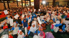Sebanyak 1.500 anak yatim dan duafa mengikuti kegiatan menulis surat untuk Presiden Jokowi di TMII, Jakarta, Minggu (19/6). Kegiatan tersebut untuk memacu anak berani menuangkan gagasan dan harapannya melalui tulisan tangan. (Liputan6.com/Yoppy Renato)