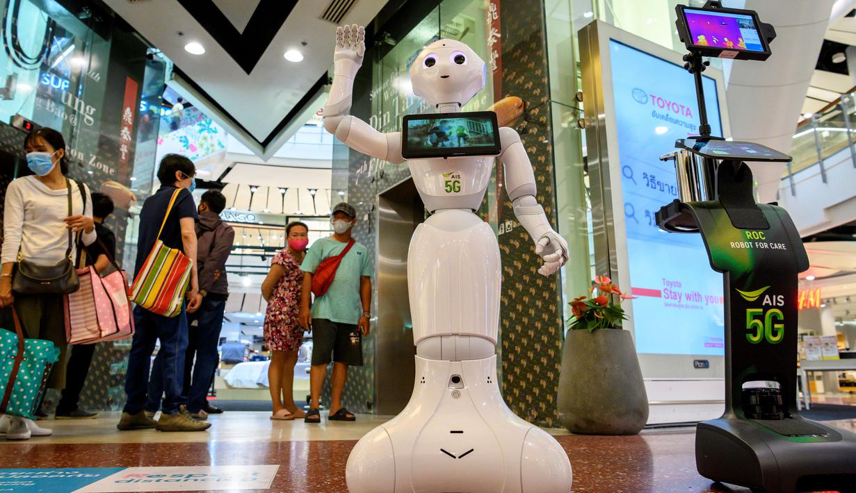 Robot 5G menyambut pengunjung yang mendatangi pusat perbelanjaan di Bangkok, Thailand, Kamis (4/6/2020). Thailand menggunakan teknologi di garis depan untuk menjaga ruang publik dari penyebaran pandemi corona Covid-19. (Mladen ANTONOV / AFP)