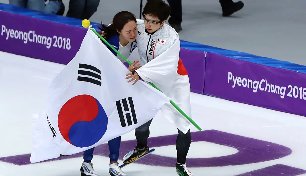 Peraih medali emas, skater Nao Kodaira dari Jepang memeluk dan menghibur peraih perak, skater Lee Sang Hwa dari Korea Selatan setelah cabang skating speed 500 meter putri di Olimpiade Musim Dingin Pyeongchang 2018, Minggu (18/2). (AP/Eugene Hoshiko)