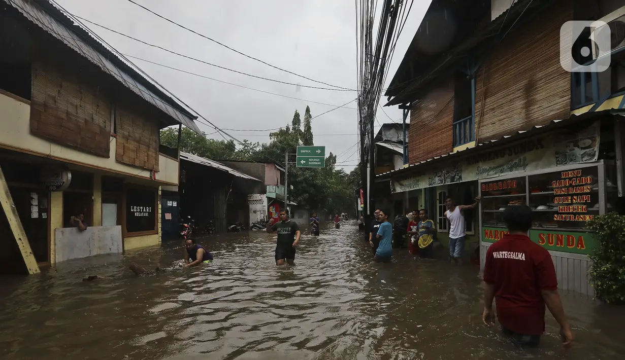 Warga beraktivitas diarea lingkungannya yang tergenang banjir di Jalan Hang Lekir, Kebayoran Lama, Jakarta Selatan, Rabu (1/1/2020). Banjir tersebut disebabkan karena tingginya intensitas hujan yang mengguyur sejak Selasa (31/12/2019). (Liputan6.com/Johan Tallo)
