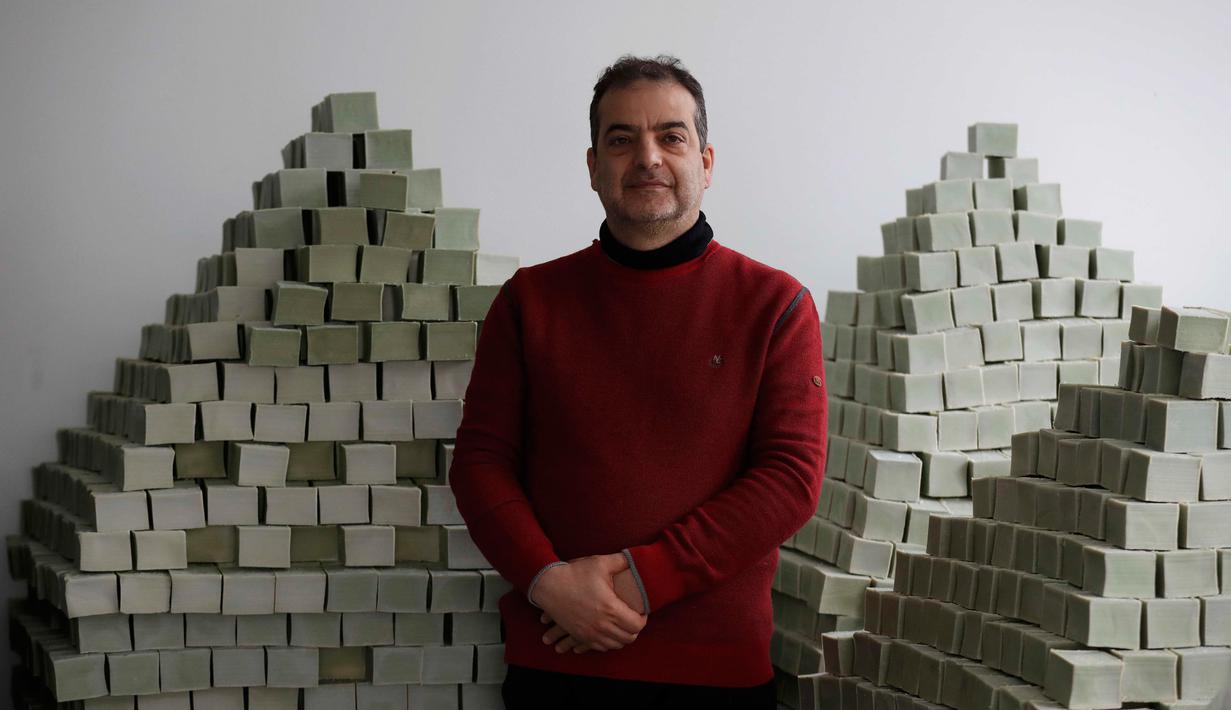 Pengusaha sabun dari Aleppo, Samir Constantini berpose di dekat tumpukan sabun di pabrik Alepia, Paris, Kamis (22/12). Sudah bertahun-tahun lamanya Aleppo dikenal sebagai pembuat sabun zaitun dengan kualitas terbaik. (REUTERS / Christian Hartmann)