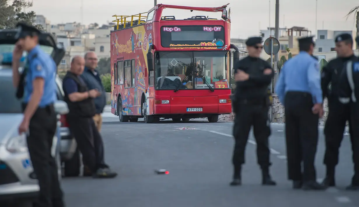 Petugas kepolisian berdiri dekat sebuah bus tingkat beratap terbuka yang menabrak dahan pohon di Zurrieq, Malta, Senin (9/4). Sedangkan supir bus berusia 24 tahun yang tidak diketahui namanya tidak terluka. (AP Photo/Rene Rossignaud)