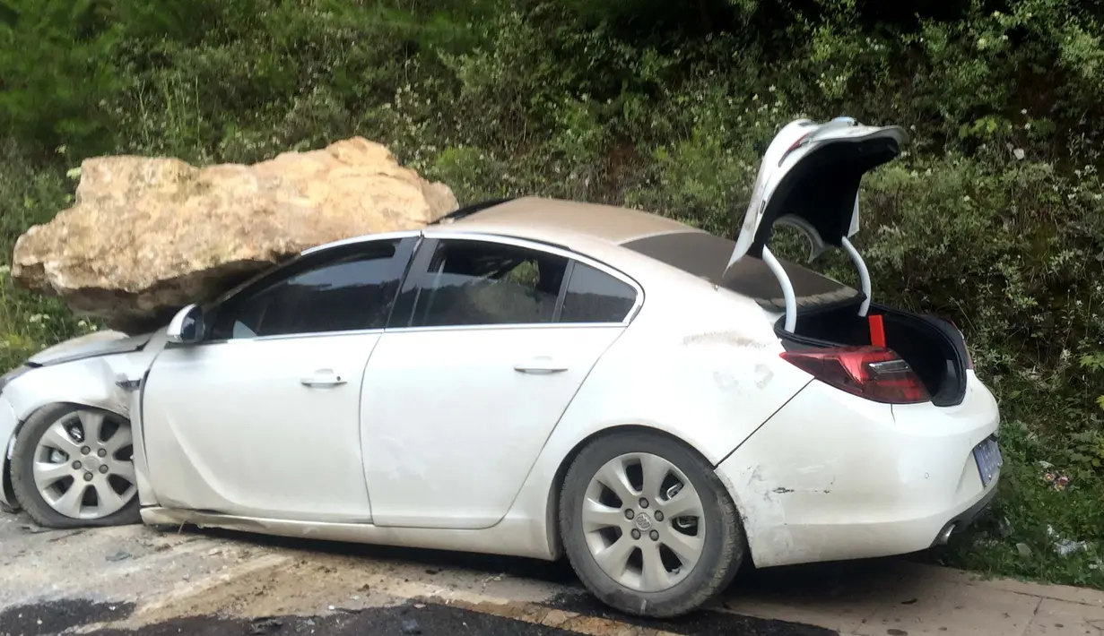 Mobil tertimpa batu saat terjadi gempa terlihat di Jiuzhaigou di provinsi Sichuan barat daya China (9/8). Menurut sumber pemerintah, korban diperkirakan akan meningkat saat berita turun dari wilayah pegunungan yang terpencil. (AFP Photo/Str/China Out)