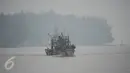 Nelayan berlayar dengan perahu di sungai Narathiwat yang diselimuti kabut asap, Thailand, Senin (5/10/2015). Kabut asap dari kebakaran hutan di Indonesia kini menyelimuti provinsi di wilayah selatan Thailand. (AFP PHOTO/Madaree TOHLALA)