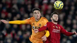 Pemain Wolvehampton Wanderers,  Max Kilman berebut bola dengan  gelandang Liverpool, Adam Lallana pada pekan ke-20 Liga Inggris 2019-2020 di Anfield, Minggu (29/12/2019). Liverpool semakin perkasa di Premier League setelah menang 1-0 atas Wolverhampton. (AP/Jon Super)