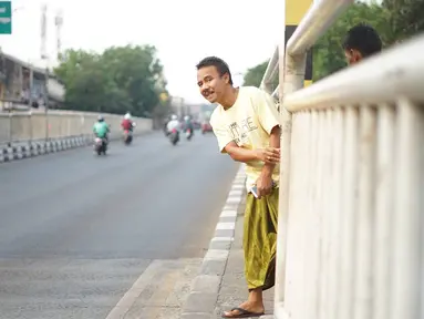 Warga menerobos celah pagar pembatas jalan di depan Stasiun Pasar Minggu, Jakarta, Rabu (16/10/2019). Jauhnya jembatan penyeberangan orang (JPO) membuat warga memanfaatkan celah pagar pembatas tersebut sebagai akses menyeberang, meski berbahaya bagi keselamatan. (Liputan6.com/Immanuel Antonius)