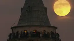 Bulan purnama terakhir tahun ini yang dikenal sebagai Cold Moon muncul di belakang menara Galata di Istanbul, Turki, Rabu (7/12/2022). Dijuluki Cold Moon karena Bulan purnama ini terbit pada salah satu malam “terpanjang” dalam setahun karena kedekatannya dengan titik balik Matahari musim dingin di Desember. (AP Photo/Emrah Gurel)