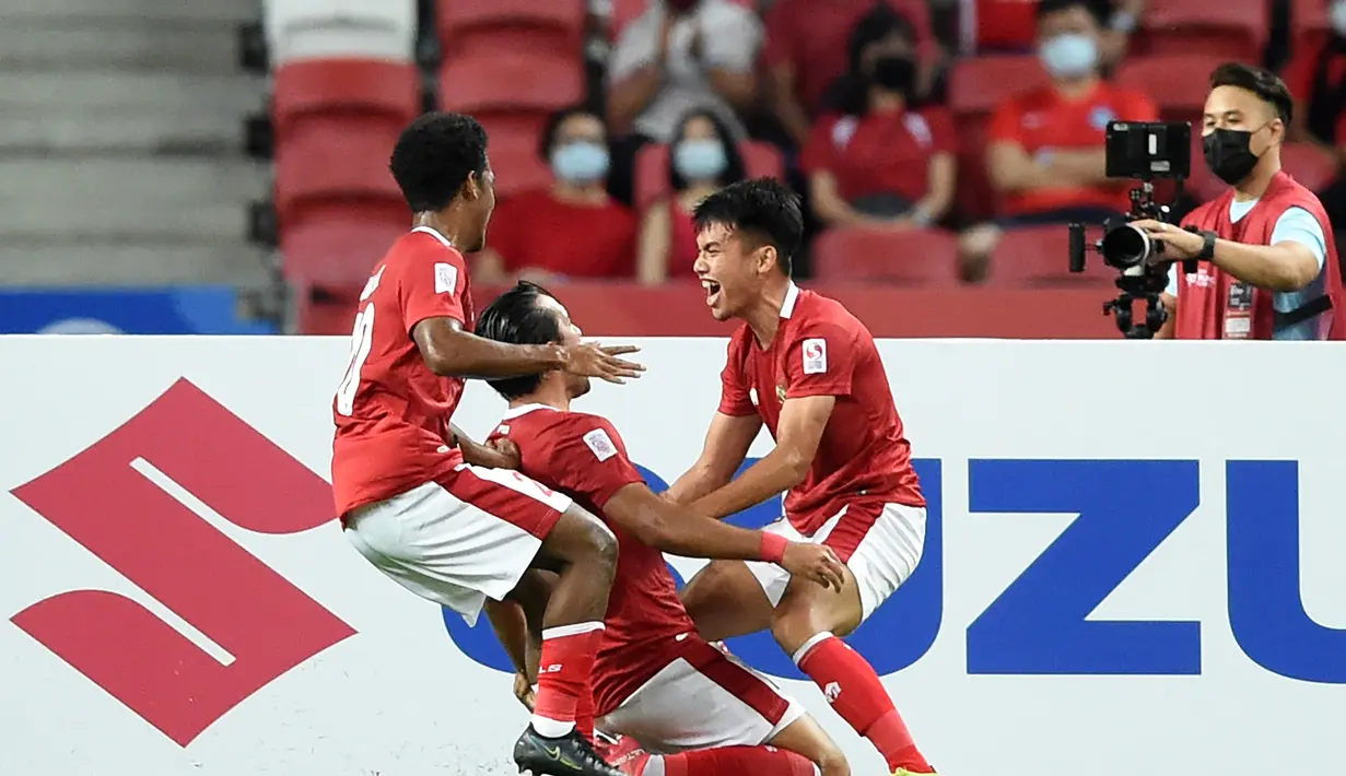 Penyerang Timnas Indonesia, Ezra Walian (tengah) berselebrasi dengan rekan setimnya usai mencetak gol ke gawang Singapura pada leg kedua semifinal Piala AFF 2020 di National Stadium, Sabtu (25/12/2021). Laga dimenangkan Indonesia 4-2 lewat perpanjangan waktu 2 x 15 menit. (AFP/Roslan Rahman)