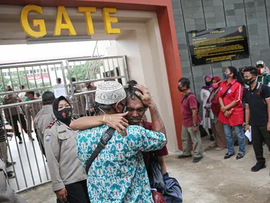 Seorang pengunjuk rasa yang menolak UU Cipta Kerja memeluk orang tuanya di Polda Metro Jaya, Jakarta, Rabu (14/10/2020). Mereka diamankan petugas Kepolisian karena diduga terlibat kericuhan saat unjuk rasa menolak UU Cipta Kerja pada Selasa (14/10/2020). (Liputan6.com/Faizal Fanani)