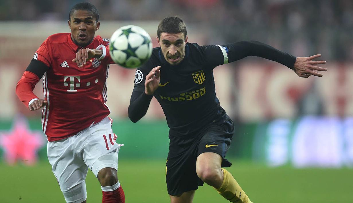 Gelandang Bayern Munchen, Douglas Costa, berebut bola dengan bek Atletico Madrid, Sime Vrsaljko. Munchen berhasil melepaskan empat kali tembakan ke arah gawang sementara Atletico melakukan tiga kali. (AFP/Christof Stache)