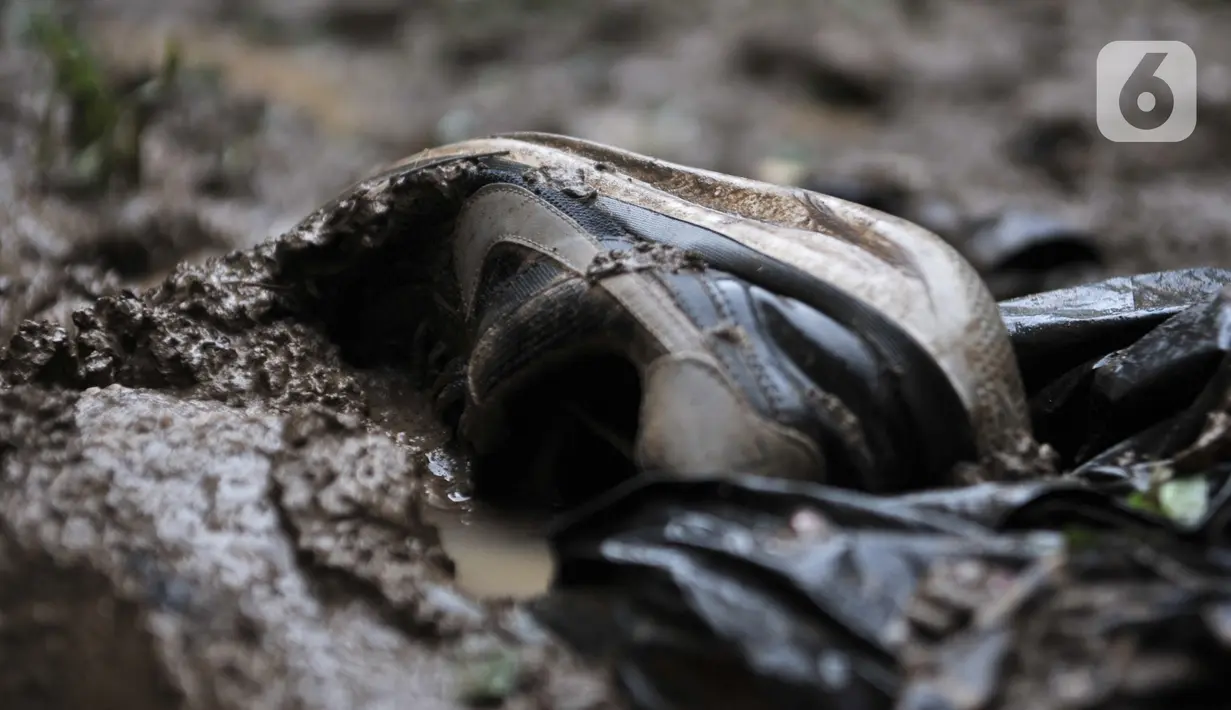 Sepatu tergeletak di salah satu rumah warga pascabanjir di kawasan Rawajati, Pancoran, Jakarta, Minggu (5/1/2020). Puluhan rumah warga yang berada di bantaran Kali Ciliwung itu mengalami kerusakan parah dan dipenuhi sampah serta lumpur akibat terjangan banjir. (merdeka.com/Iqbal Nugroho)