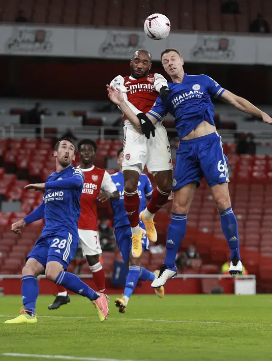 Penyerang Arsenal, Alexandre Lacazette berebut bola udara dengan bek Leicester City, Jonny Evans pada pertandingan lanjutan Liga Inggris di Stadion Emirates di London, Inggris, Minggu (25/10/2020). Leicester City menang 1-0 atas Arsenal. (AP Photo/Ian Walton,Pool)