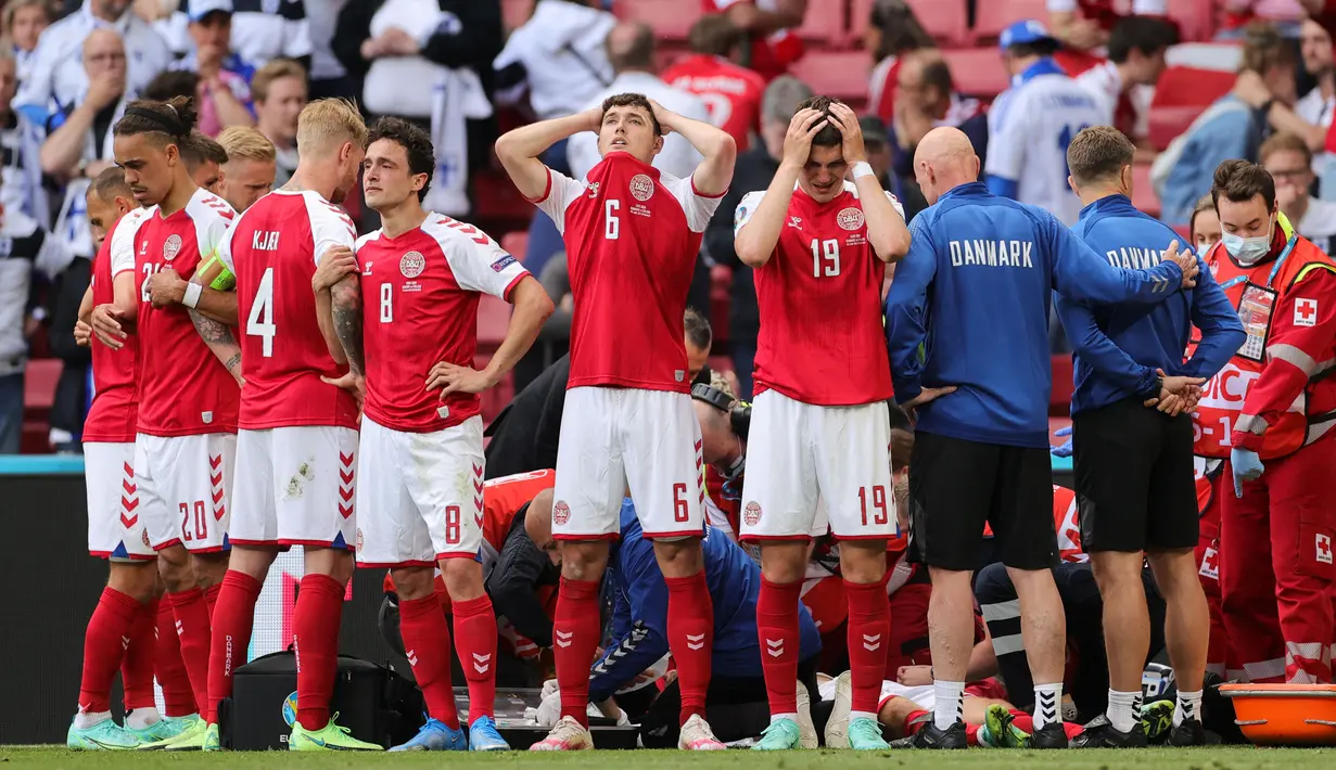 Reaksi pemain Denmark saat paramedis merawat Christian Eriksen yang jatuh pingsan di lapangan saat pertandingan sepak bola Grup B UEFA EURO 2020 saat melawan Finlandia di Stadion Parken, Kopenhagen pada 12 Juni 2021. (AFP/Pool/Friedemann Vogel)