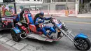 Wakil kandidat untuk Partai Sosial Liberal (PSL), Luiz Carlos de Paula yang dikenal sebagai Captain America menunggangi motor besar beroda tiga saat melakukan kampanye di Sao Paulo, Brasil, 26 September 2018. (AFP/NELSON ALMEIDA)