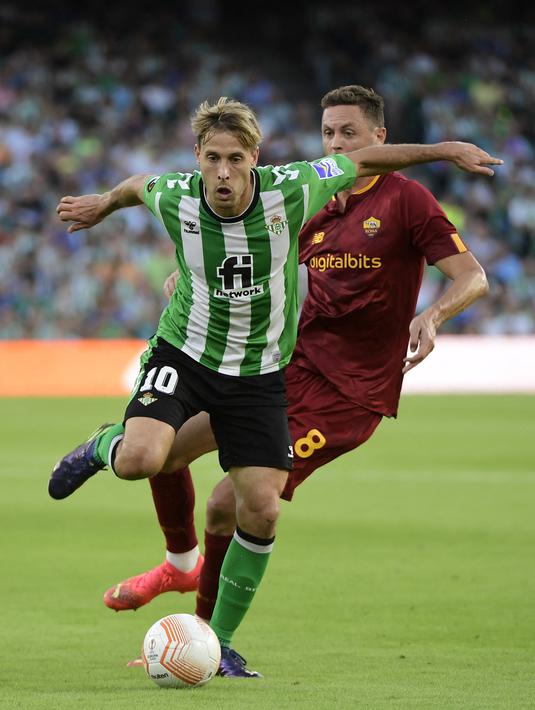 Gelandang Real Betis Sergio Canales berebut bola dengan pemain tengah AS Roma Nemanja Matic (kanan) pada laga pekan ke-4 Grup C Liga Europa 2022/2023  di Estadio Benito Villamarin, Kamis (13/10/2022). Kedua tim harus puas berbagi poin usai bermain imbang 1-1. (Photo by CRISTINA QUICLER / AFP)