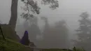 Seorang wanita berjalan di bawah kabut tebal, Dharmsala, India, 10 Agustus 2020. (AP Photo/Ashwini Bhatia)