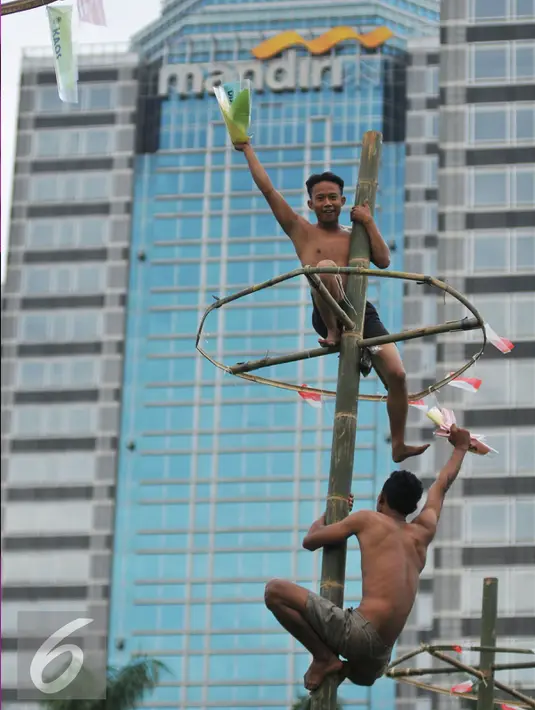 Keceriaan peserta saat mendapatkan hadiah  diatas batang pohon pinang dalam rangka merayakan HUT Kemerdekaan RI ke-71 di lapangan ex Golf Driving Range Senayan, Jakarta, Rabu (17/8). (Liputan6.com/Gempur M Surya)