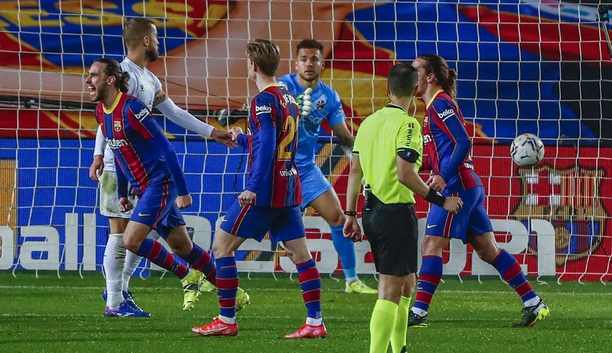 Bek Barcelona, Oscar Mingueza (kiri) melakukan selebrasi usai mencetak gol ketiga timnya ke gawang SD Huesca dalam laga lanjutan Liga Spanyol 2020/2021 pekan ke-27 di Camp Nou Stadium, Barcelona, Senin (15/3/2021). Barcelona menang 4-1 atas SD Huesca. (AP/Joan Monfort)