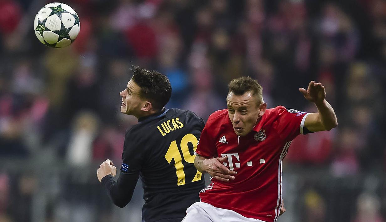Bek Bayern Munchen, Rafinha, duel udara dengan bek Atletico Madrid, Lucas Hernndez. Munchen lolos ke babak 16 besar dengan predikat runner-up Grup D. (AFP/Guenter Schiffmann)