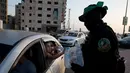 Pria bersenjata dan bertopeng Hamas membagikan takjil kepada pengendara mobil jelang berbuka puasa Ramadan di Kota Gaza, Palestina, Kamis (16/5/2019). (AP Photo/Hatem Moussa)