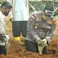 Kasat Sabhara Polrestabes Palembang AKBP Sonny Triyanto tak segan turut membantu petugas pemakaman, menggali liang lahat jenasah pasien Covid-19 di TPU Gandus Hills Palembang (Liputan6.com / Nefri Inge)