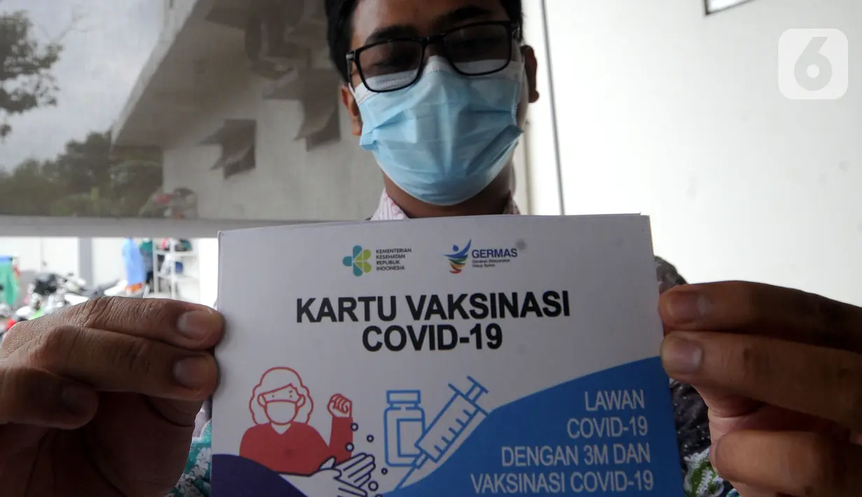 Seorang pria menunjukkan Kartu Vaksinasi COVID-19 saat kegiatan vaksinasi di Puskemas Jagakarsa, Jakarta Selatan, Kamis (14/1/2020). Sejumlah Puskesmas di Jabodetabek mulai melakukan vaksinasi COVID-19 pada hari ini. (merdeka.com/Arie Basuki)