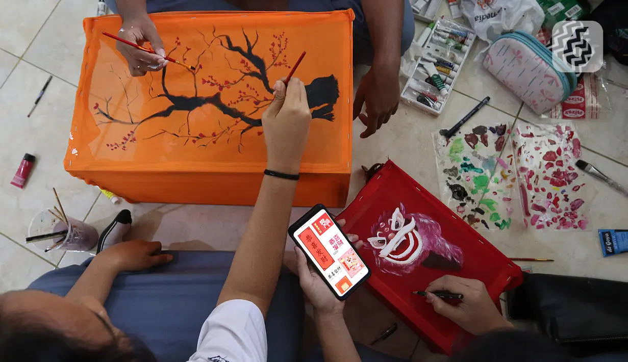 Siswa siswi sedang membuat lukisan bernuansa imlek menggunakan media lampion di SMA Negri 39 Jakarta, Selasa (21/1/2020). Kerajinan lukisan tersebut dibuat oleh siswa untuk menyambut hari imlek 2571 yang jatuh pada Sabtu (25/1) 2020. (Liputan6.com/Herman Zakharia)