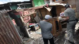 Seorang warga saat membawa barang miliknya di kawasan rusun tanah tinggi, Jakarta, Rabu (4/3/2015).  Sebanyak 10 bangunan liar di Rumah Susun (Rusun) Tanah Tinggi ditertibkan aparat satpol PP. (Liputan6.com/Faizal Fanani)