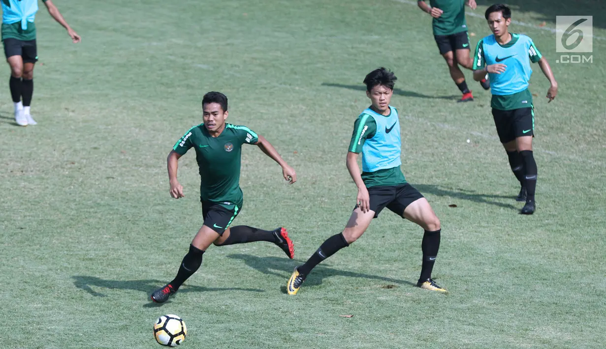 Pemain Timnas Indonesia U-19, Nur Hidayat (kiri) berebut bola dengan Febri Eka saat latihan di Lapangan B Kompleks GBK, Jakarta, Selasa (18/9). Latihan ini persiapan  PSSI Anniversary Cup U-19 dan Piala AFC U19. (Liputan6.com/Helmi Fithriansyah)