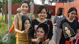 Sejumlah penggemar membawa poster muka Selena Gomez sebelum menyaksikan konser di ICE BSD CITY, Tanggerang, (23/7). Selena Gomez menggelar konser yang bertajuk "REVIVAL TOUR" di ICE BSD CITY yang akan di mulai jam 20.00. (Liputan6.com/Herman Zakharia)