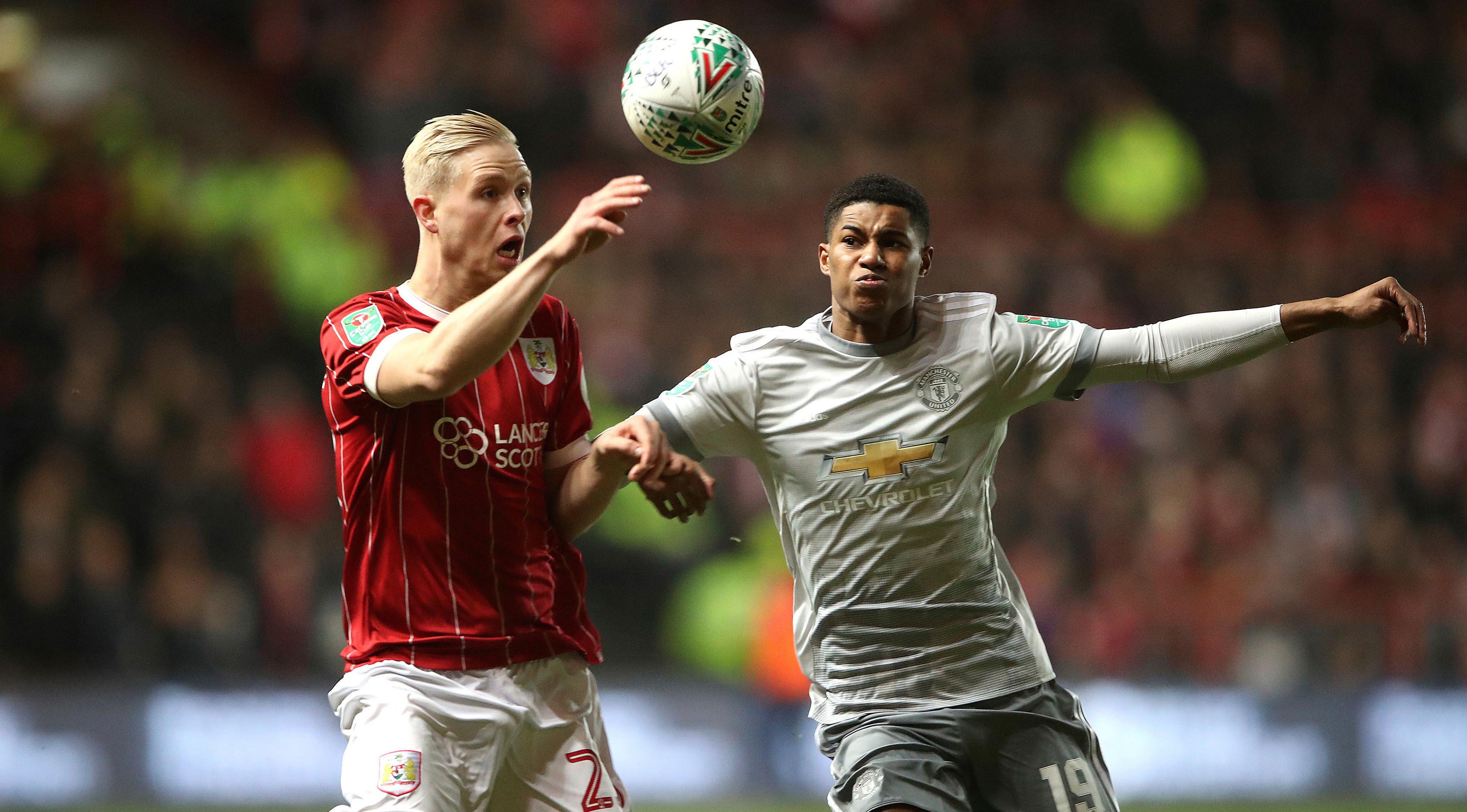 Pemain Bristol City, Hordur Bjorgvin Magnusson berebut bola dengan pemain Manchester United, Marcus Rashford pada perempat final Piala Liga Inggris di Ashton Gate, Kamis (21/12). MU gagal ke babak empat besar setelah kalah 1-2. (Nick Potts/PA via AP)