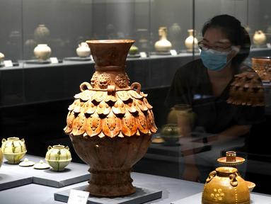 Pengunjung mengamati benda-benda yang dipajang dalam pameran keramik di Zhengzhou, Provinsi Henan, China, 25 Agustus 2020. Pameran keramik tersebut menampilkan 100 lebih benda dari zaman kuno yang ditemukan di sepanjang cekungan Sungai Kuning. (Xinhua/Li An)
