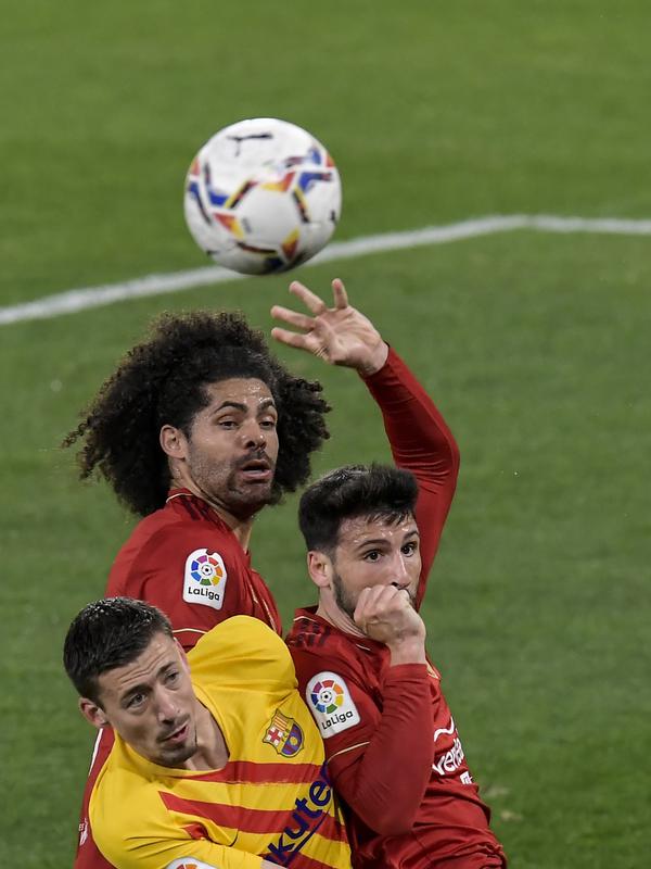 Bek Barcelona, Clement Lenglet berebut bola udara dengan dua pemain Osasuna, Jonathan Calleri dan Aridane pada pertandingan lanjutan La Liga Spanyol di stadion El Sadar di Pamplona, Spanyol, Minggu (7/3/2021). Barcelona menang atas Osasuna 2-0. (AP Photo/Alvaro Barrientos)